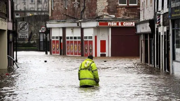 Un hombre camina por las calles inundadas de Dumfries, al sur de Escocia