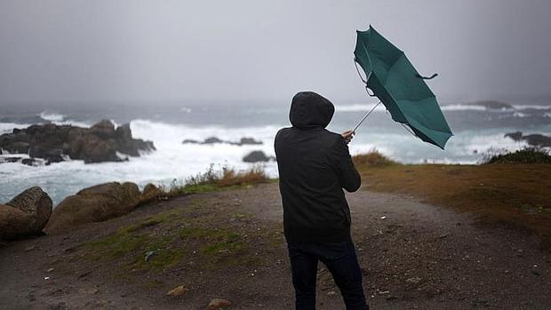 Un hombre ve como el viento le dobla el paraguas en La Coruña. Lluvia generalizada y viento con fuertes rachas marcaron la jornada de ayer en Galicia