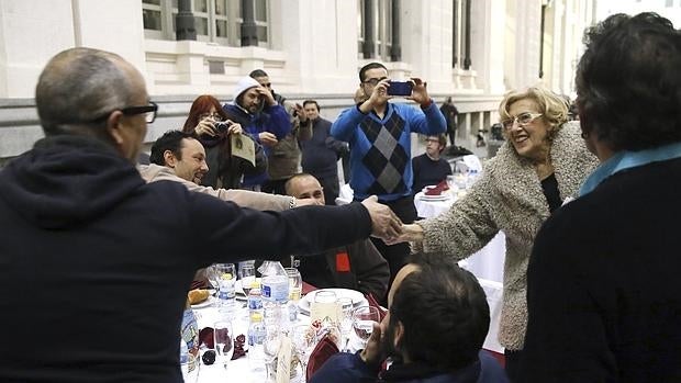 Carmena saluda a algunos de los comensales en la cena de Nochebuena en el Palacio de Cibeles