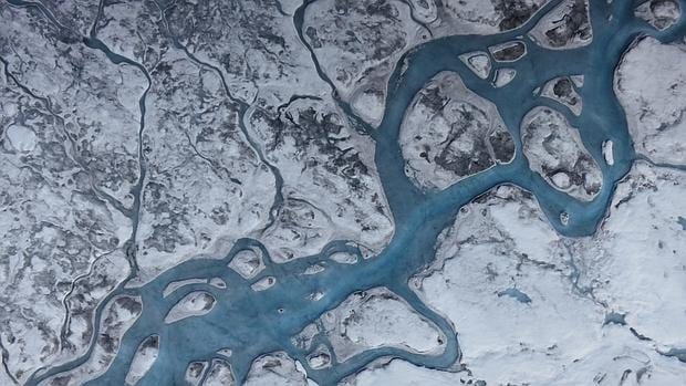 Esta vista aérea de Groenlandia muestra ríos de agua de deshielo y áreas de hielo oscuro