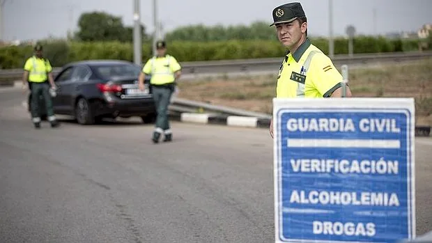 Varios agentes de la Guardia Civil de Tráfico preparan un control de alcoholemia y drogas este mediodía en la localidad de Puçol (Valencia)