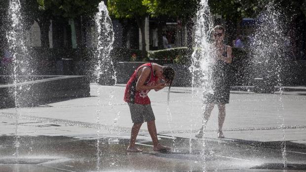 Un joven se refresca en una fuente de Córdoba