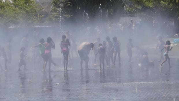 Numerosas personas se refrescan en una fuente de Madrid Río en una jornada marcada por las altas temperaturas