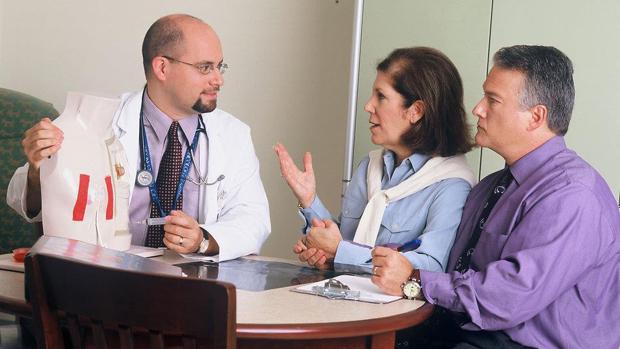 Un doctor y una pareja hablando