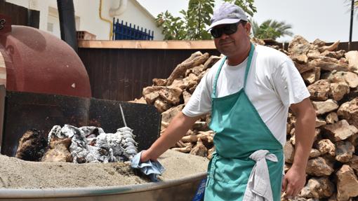 Luis, originario de la India, se dedica a hacer espeto de sardinas