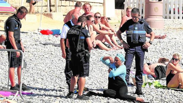 Imagen de la policía francesa obligando a una mujer a quitarse el «burkini» en Niza