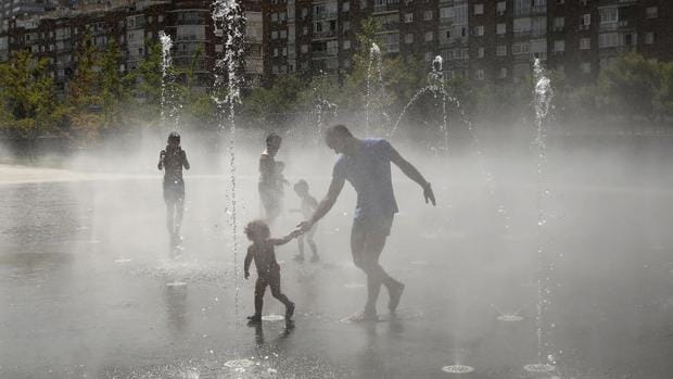 Una familia se refresca en una de las fuentes del parque Madrid Río para combatir las altas temperaturas del último fin de semana de agosto, en la capital