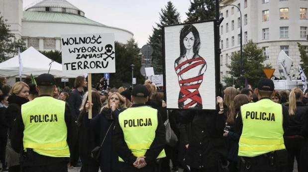 Una mujer sostiene un cartel en el que se lee «Libertad de elección no terror» durante la manifestación en contra de la prohibición del aborto