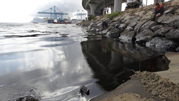 Un camión cisterna absorbe el vertido que se encuentra en la playa de la Concha en Algeciras, hasta donde ha llegado el derrame de crudo, de 500 litros mezclado con agua, causado por un fallo mecánico en una monoboya (almacén flotante de crudo) de Cepsa en la Bahía de Algeciras