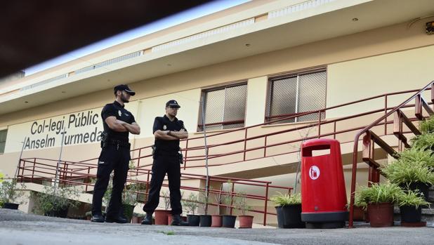 Dos policías locales permanecen a la entrada del colegio público Anselm Turmeda del barrio obrero de Son Roca de la capital balear