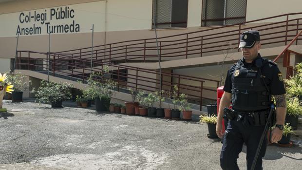 Un agente de policía en el colegio público del barrio obrero de Son Roca de la capital balear, donde el pasado miércoles una niña de 8 años fue, aparentemente, agredida por cerca de una docena de estudiantes mayores que ella, de entre 12 y 14 años, cuando les cogió la pelota con la que jugaban al sonar el timbre que anunciaba el fin del recreo