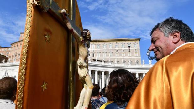 Un pregrino observa un crucifijo en la plaza de San Pedro del Vaticano