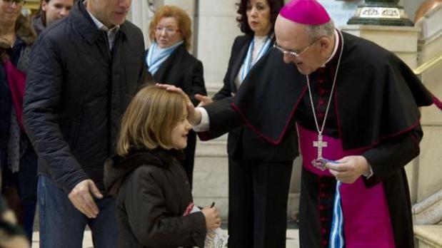 Monseñor Carlos Osoro bendice a una niña en la catedral de La Almudena durante la pasada misa de la familia