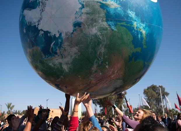 Asistentes a la Cumbre juegan con un globo terráqueo hinchable