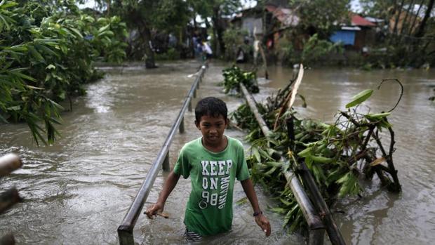 Un adolescente en una zona inundada por el paso del tifón Nock-Ten por la localidad de Pamplona, Camarines Sur