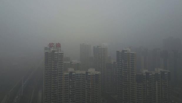 El esmog, una mezcla de niebla y partículas contaminantes, cubre los edificios en el distrito de Yanjiao en Sanhe (China)