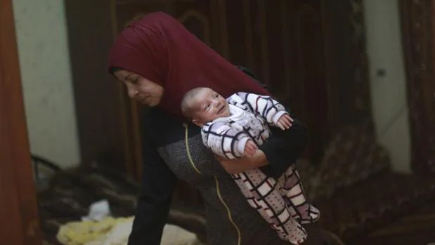 Samira Nimr lleva a su hijo Ibrahim en brazos en su casa del campo de refugiados de Nour Shams, cerca de la ciudad cisjordana de Tulkarem