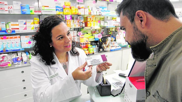 Un farmacéutico muestra una dosis del antivirus dispensado en boticas contra la meningitis B