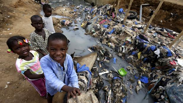 Varios niños juegan junto a un río contaminado en una barriada de chabolas en Azito, Abiyán (Costa de Marfil), antes de celebrar, hoy, el Día Mundial contra la Malaria