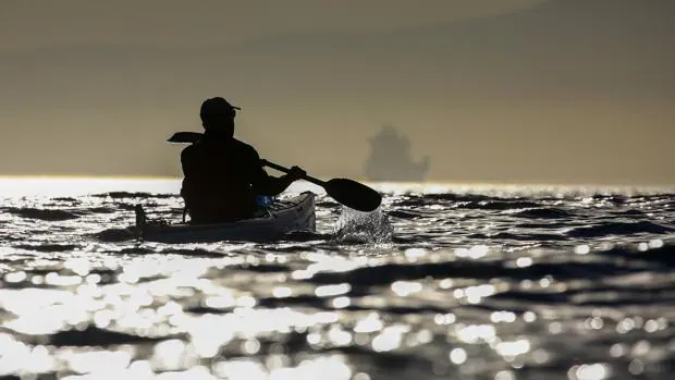 Un hombre rema en un kayak en el Océano Atlántico en la costa de Ciudad del Cabo
