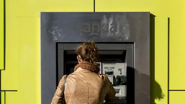 Una mujer saca dinero de un cajero de Bankia, en Valencia