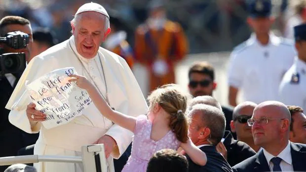 Una niña le entrega una carta al Papa durante la audiencia de este miércoles
