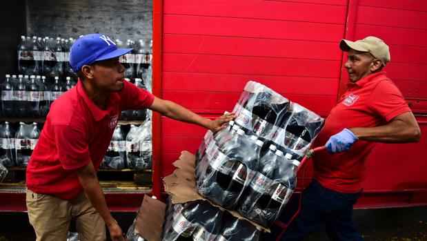 Trabajadores descargan cajas de Coca-Cola Light, con menos azúcar