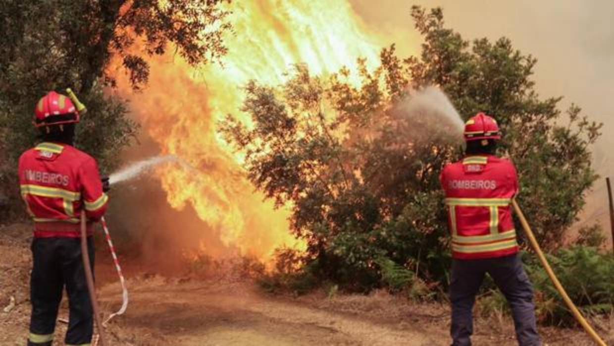 Dos bomberos portugueses combaten el fuego en Sandinha (Portugal) el pasado 20 de junio