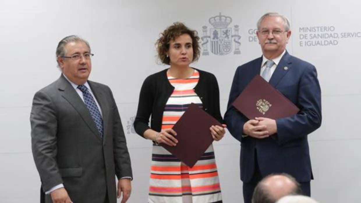 El ministro del Interior, Juan Ignacio Zoido (i), entrega al presidente de la Organización Médica Colegial (OMC), Serafín Romero (d), y a la ministra de Sanidad, Servicios Sociales e Igualdad, Dolors Monserrat (c)