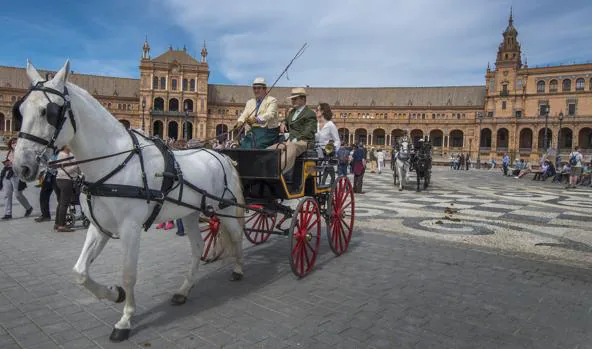 Un desfile de coches de caballos por el casco histórico de una ciudad
