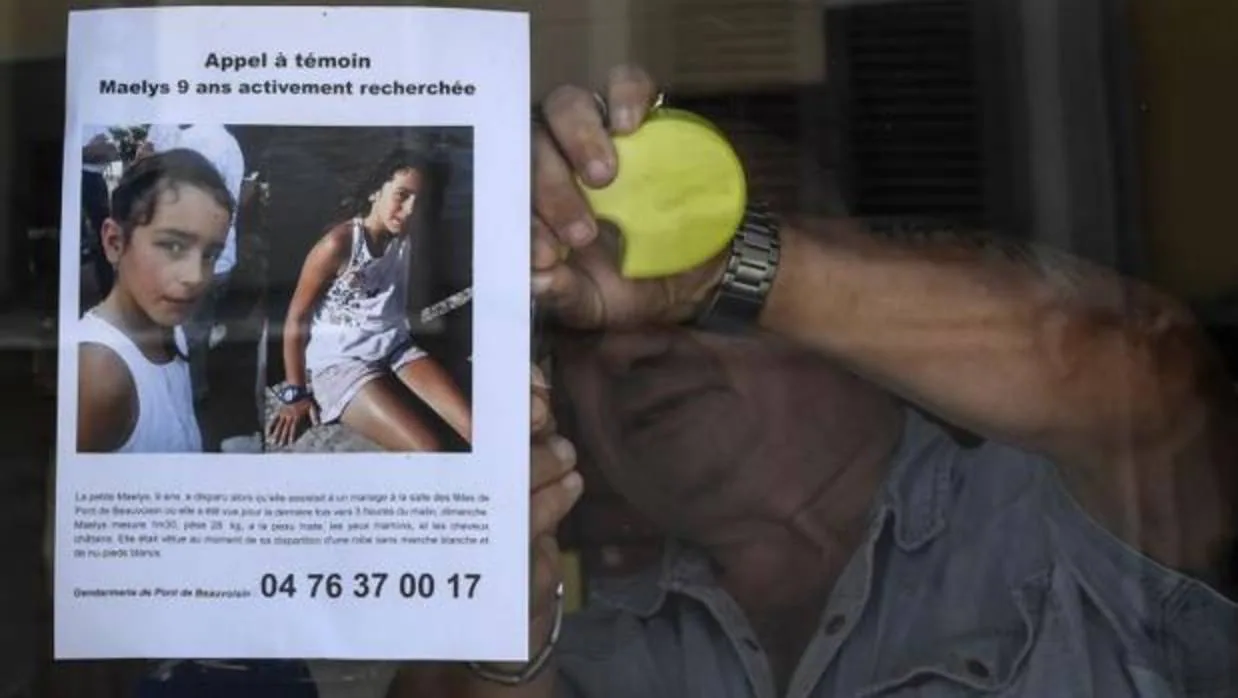 Un hombre coloca un cartel con la alerta por la desaparición de Maëlys