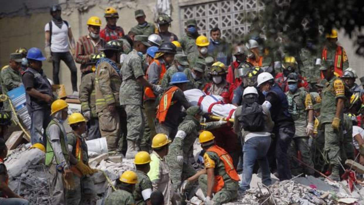 Brigadistas y voluntarios trabajan entre los escombros de los edificios colapsados durante un sismo de magnitud 7,1