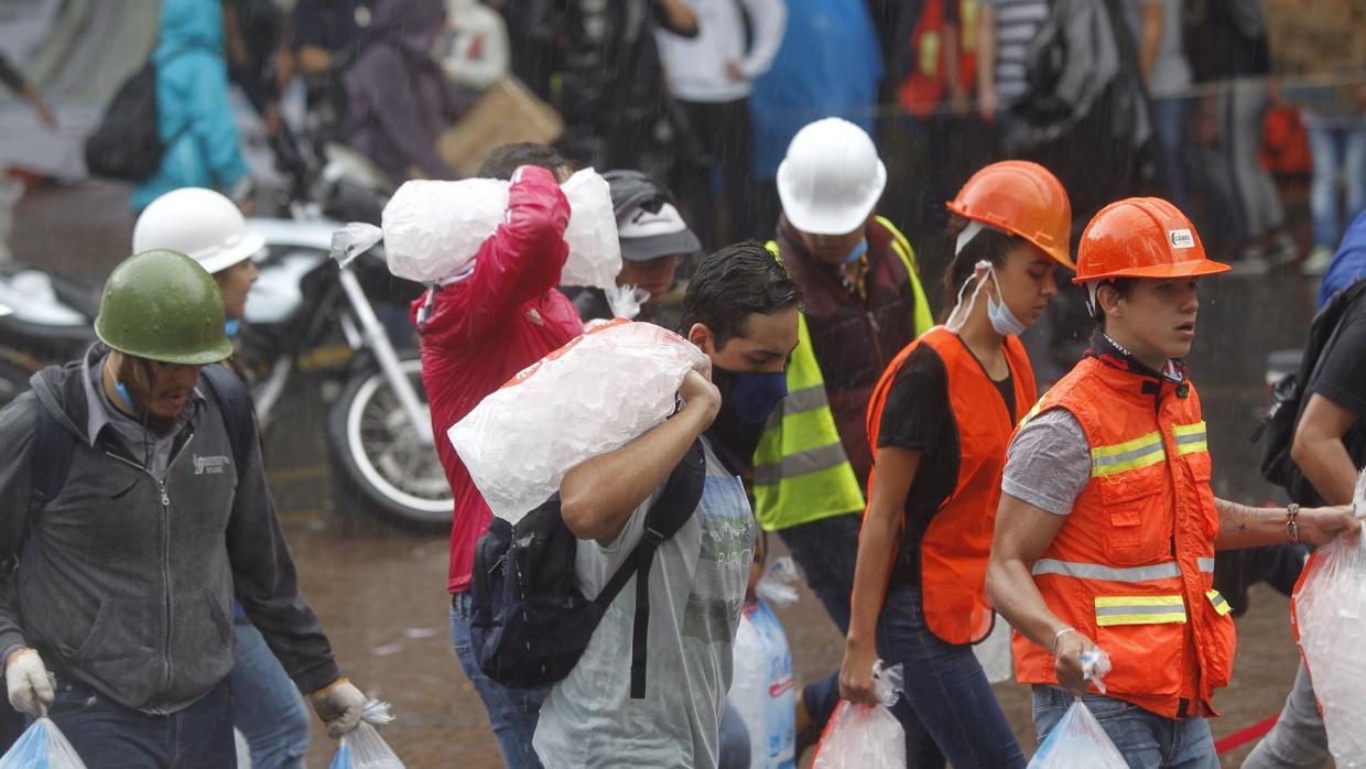 Jóvenes voluntarios llevan alimentos a un centro de abastecimiento para los damnificados