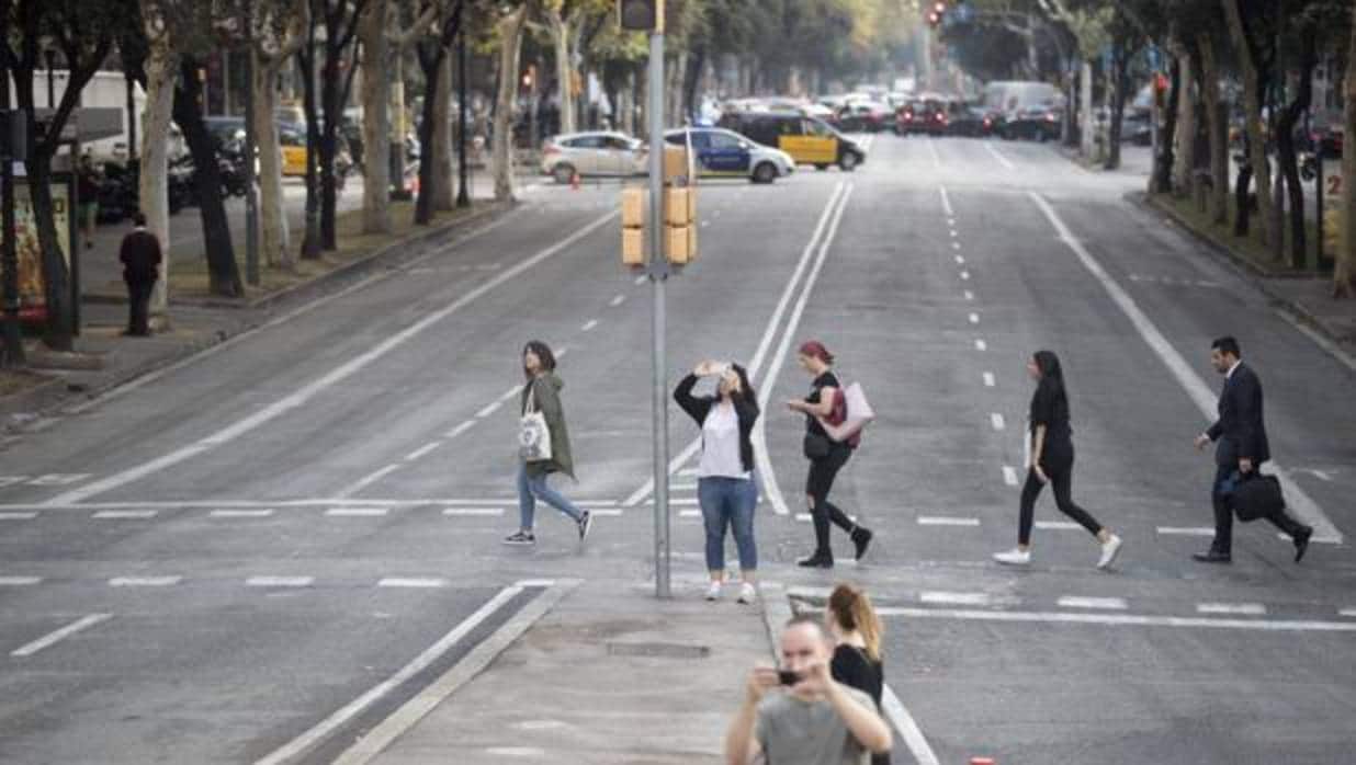 Varios peatones atraviesan la avenida Diagonal de Barcelona