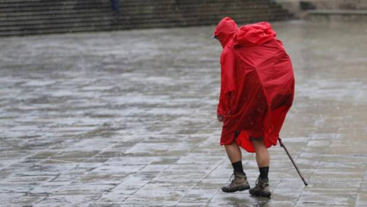 Un peregrino bajo la lluvia en la plaza de A Quintana, este jueves en Santiago de Compostela