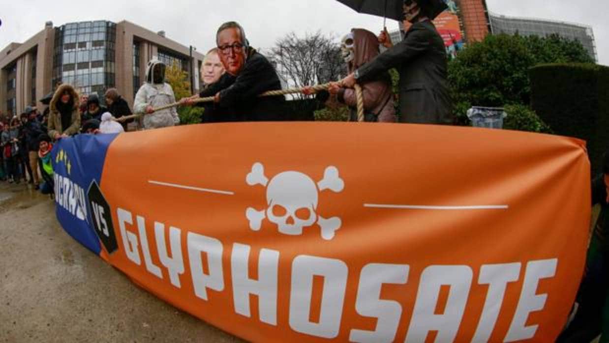 Activistas se congregan con máscaras del presidente de la Comisión Europea, Jean-Claude Juncker, y otros comisarios, en protesta contra el herbicida glifosato