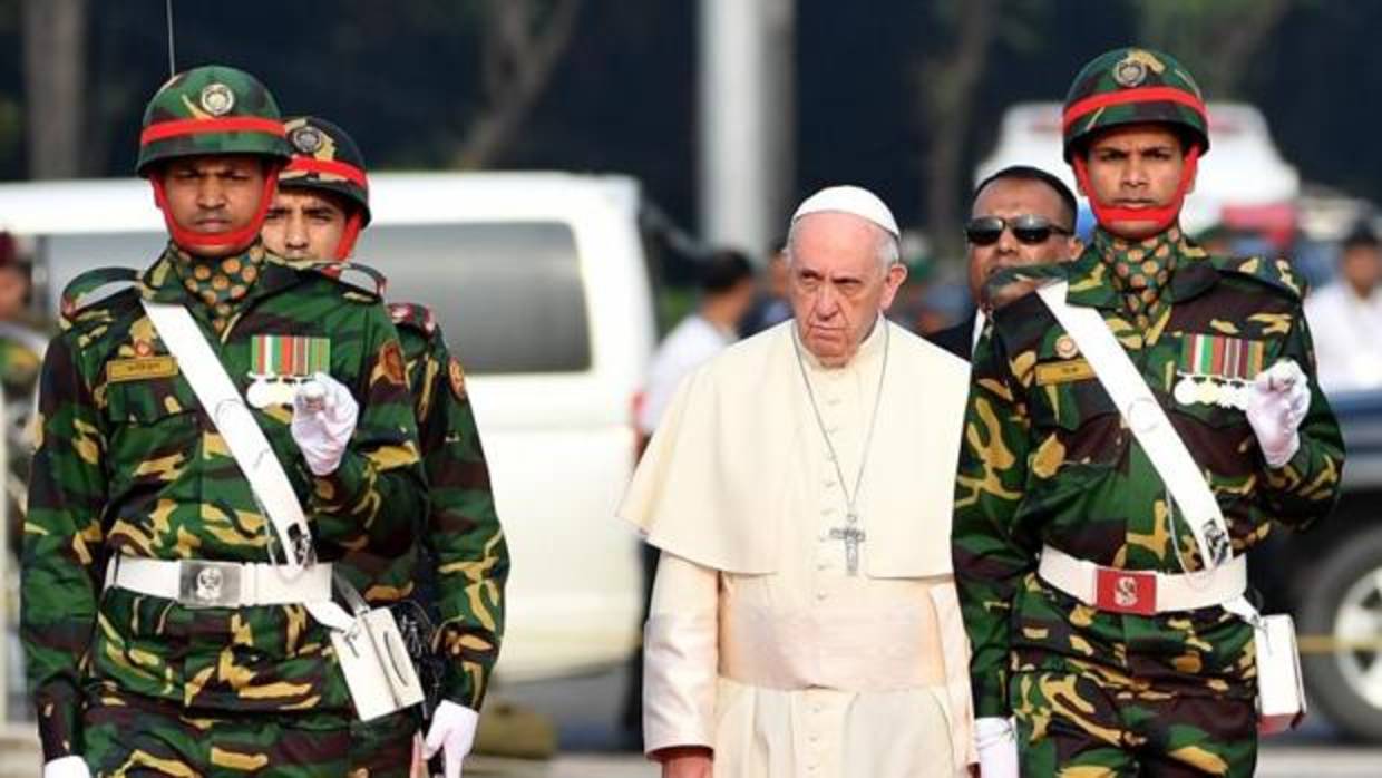 El Papa Francisco (c) pasa revista a la guardia de honor a su llegada al Aeropuerto Internacional de Daca (Bangladesh)