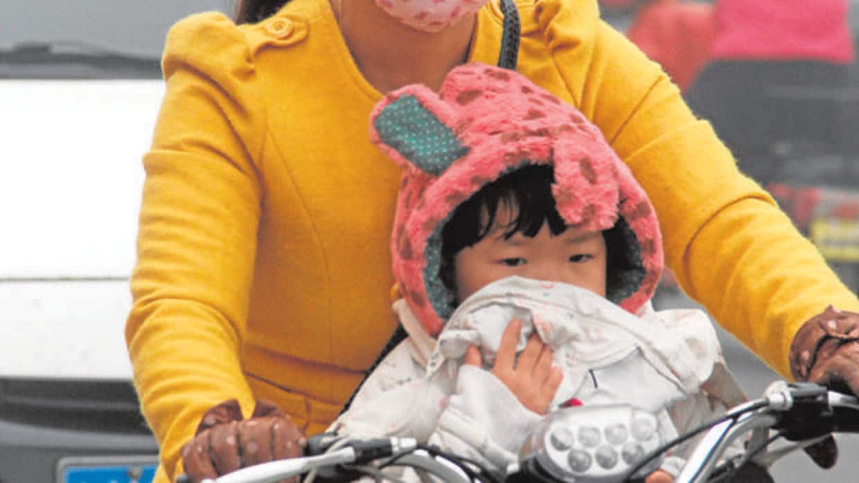 Una mujer y su hijo se protegen del «smog»