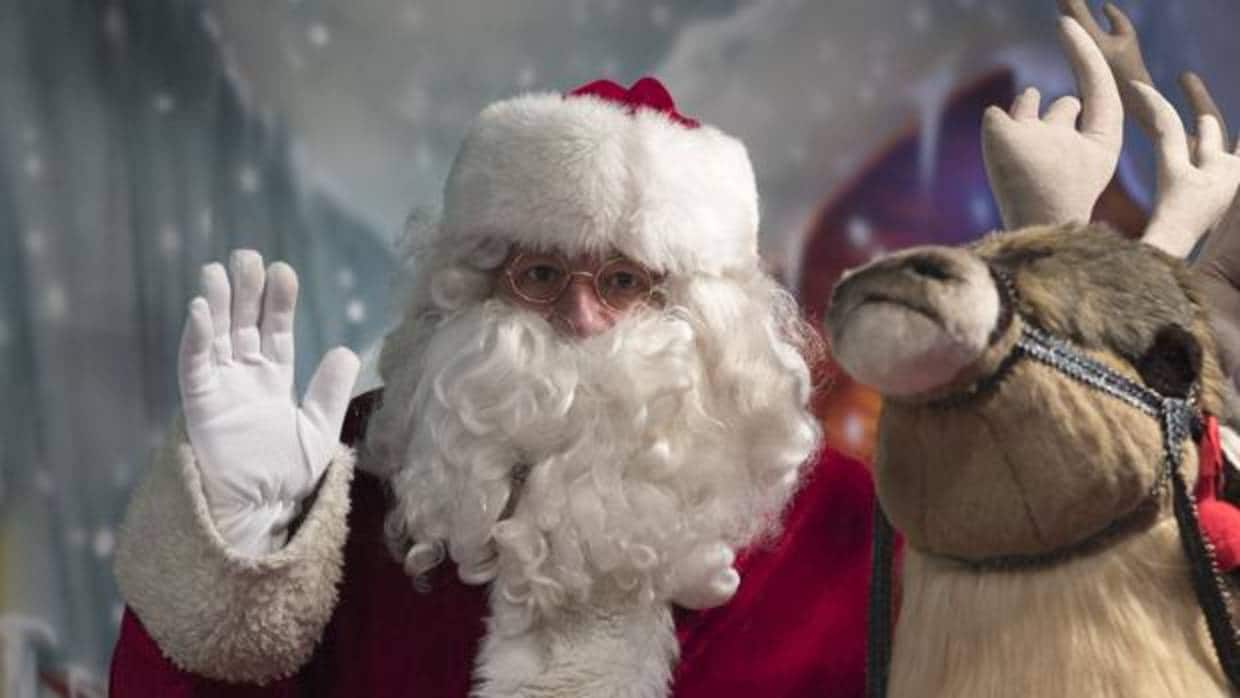 Un hombre disfrazado de Papá Noel saluda a los visitantes