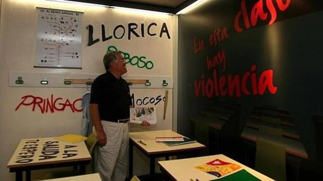 Un profesor contempla las pintadas en un aula en un caso de acoso escolar a un alumno