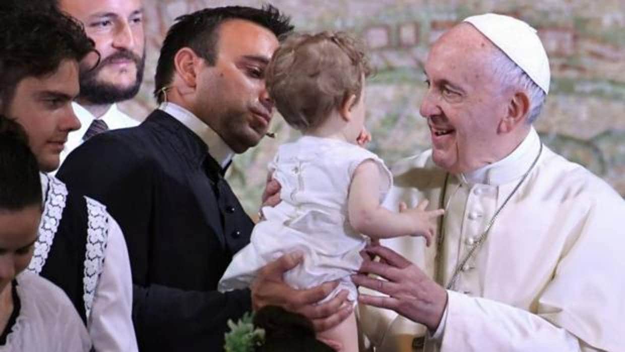 El Papa saluda a un bebé durante su visita a Nomadelfia