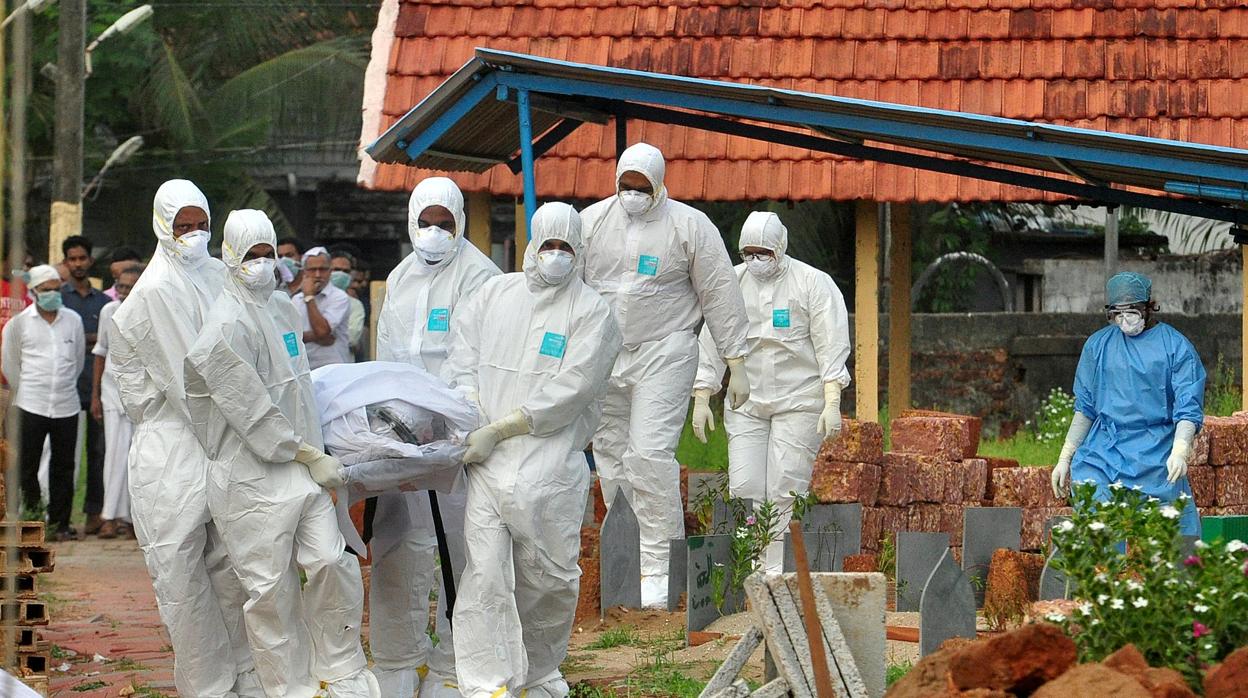 Médicos y familiares con trajes de protección cargan con el cuerpo de una víctima del virus Nipah en Kozhikode, en el sur del estado de Kerala, en la India