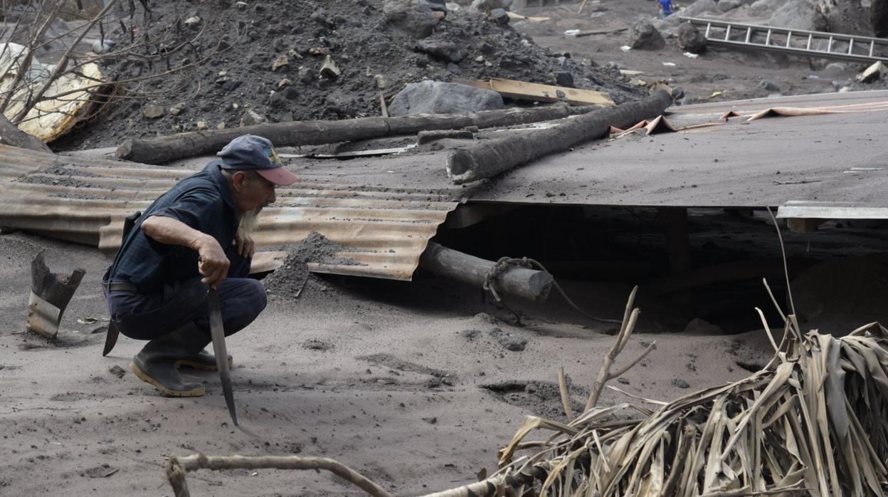 Un hombre observa los daños a una vivienda afectada por el volcán de Fuego este sábado