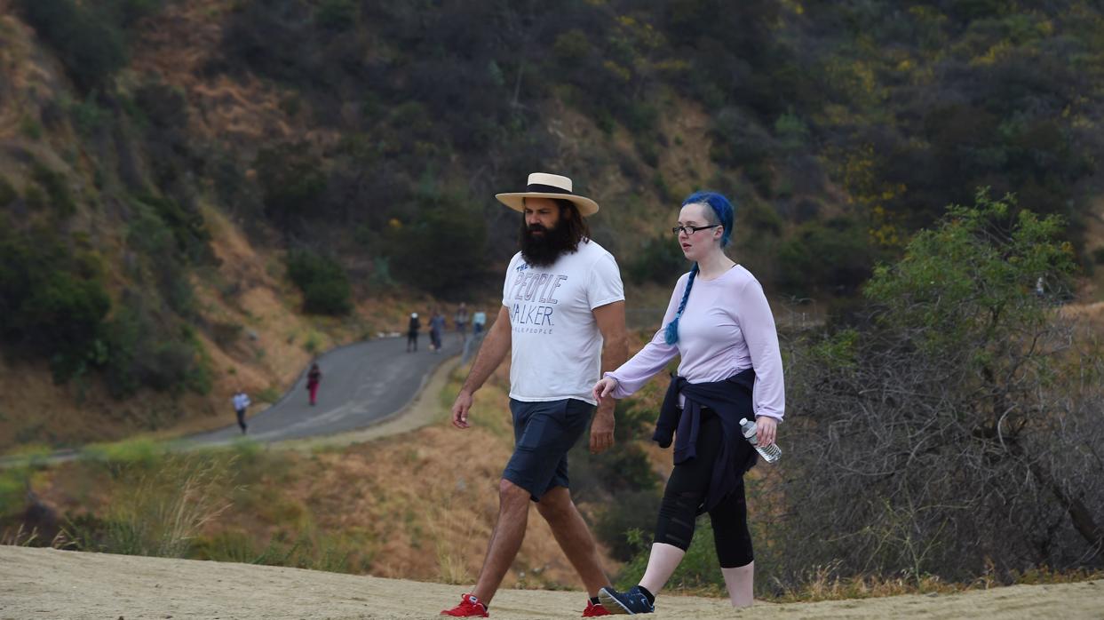 Chuck McCarthy charla con una de sus clientes mientras camina por Runyon Canyon Park en Los Angeles