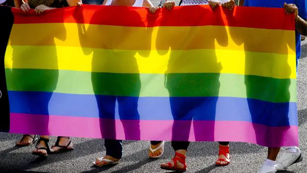 Fotografía de archivo de varias personas sujetendo una bandera el Día del Orgullo Gay