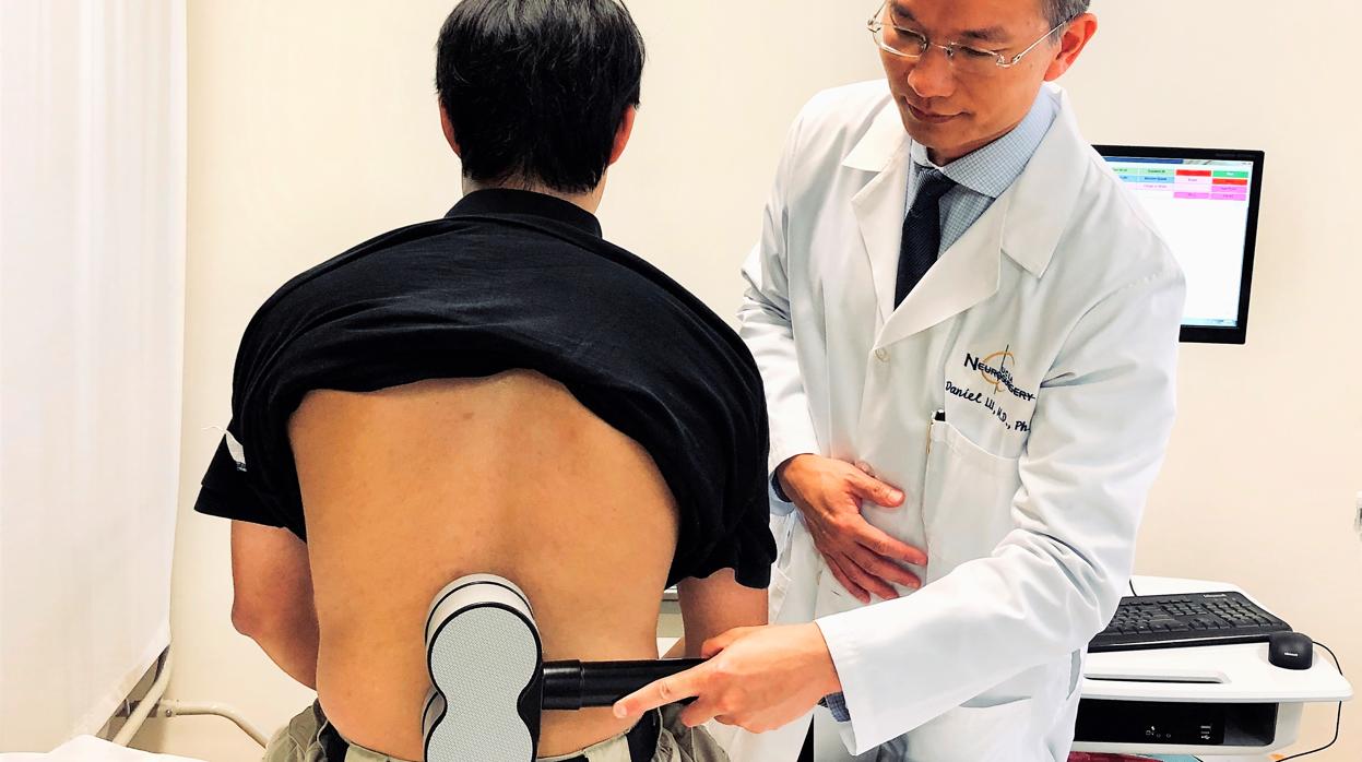 El doctor Lu estimula la zona lumbar a un paciente