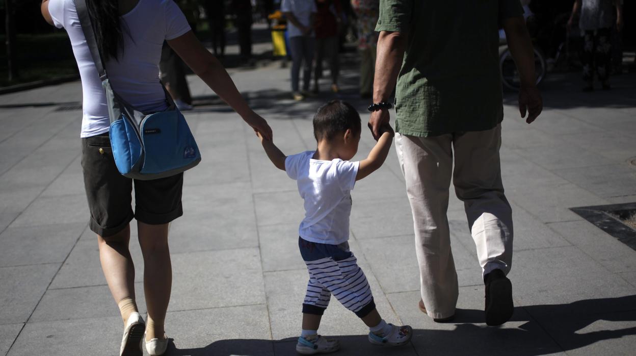 Padres chinos llevan a su hijo de la mano