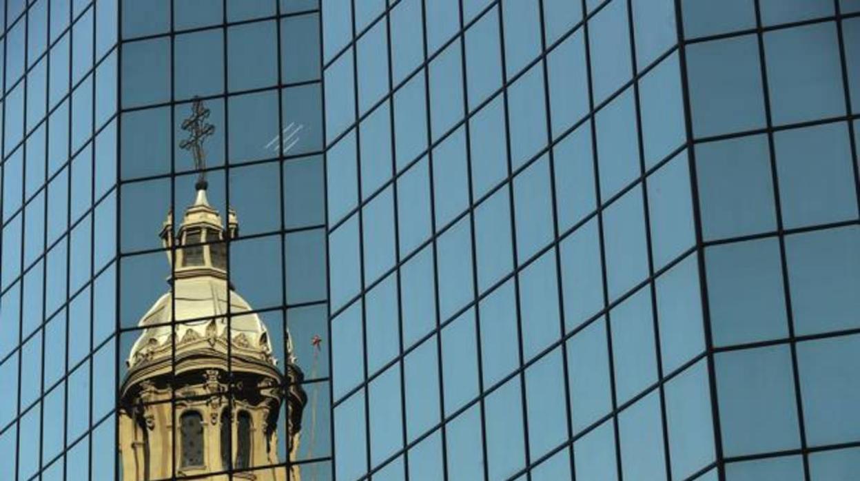 Vista de una de la cúpulas de la catedral de Santiago reflejada en un edificio