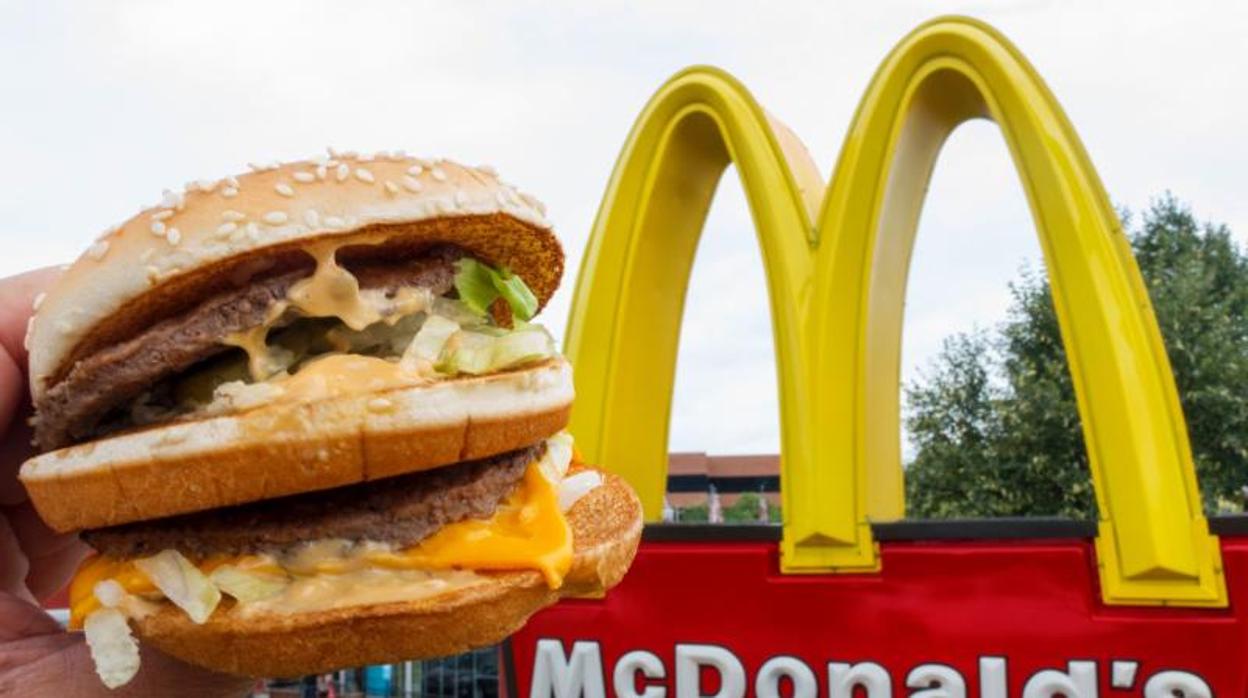 Fotografía de una hamburguesa y un cartel de McDonald's