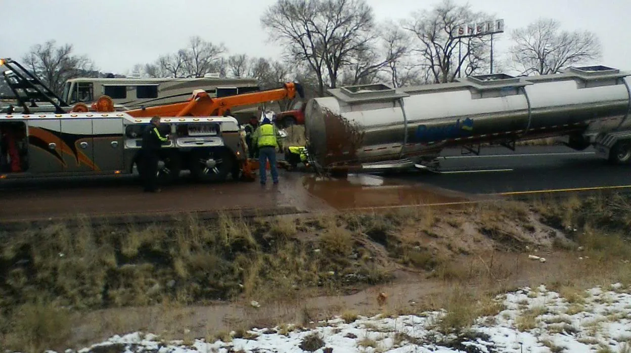 Imagen de un camión grúa intentando remolcar la cisterna de un camión accidentado